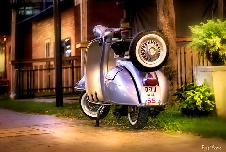 A beautifully restored 1960s Vespa motor scooter, gleaming with vibrant colors and classic design.