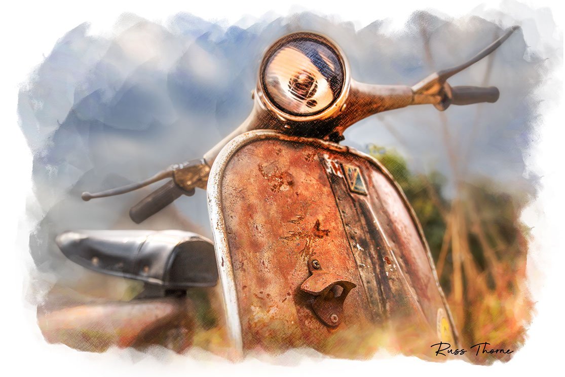 A rusting vintage Vespa scooter, partially hidden in tall weeds, reflecting years of beautiful patina.