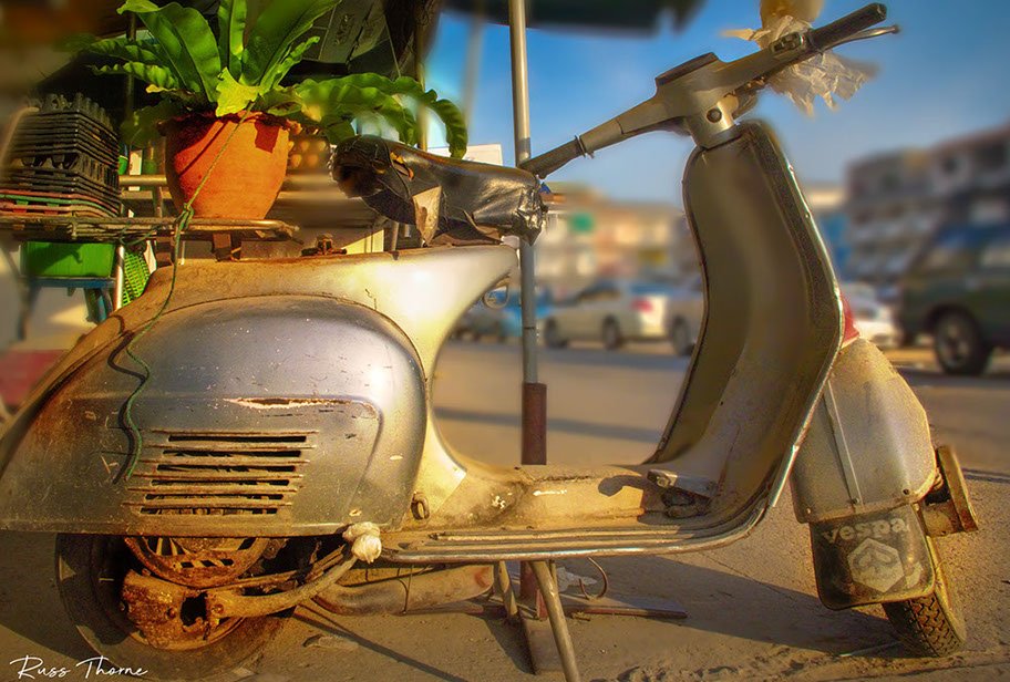 A rustic Vespa scooter, delivering eggs in Bangkok since the 1960s, exuding vintage charm and character.